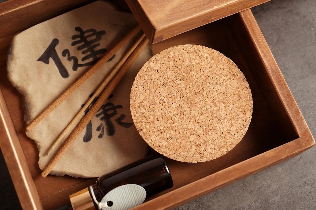 Coffret en bois, calligraphie chinoise, pierre de cor et flacon d'huile essentielle, symboles de la transmission traditionnelle